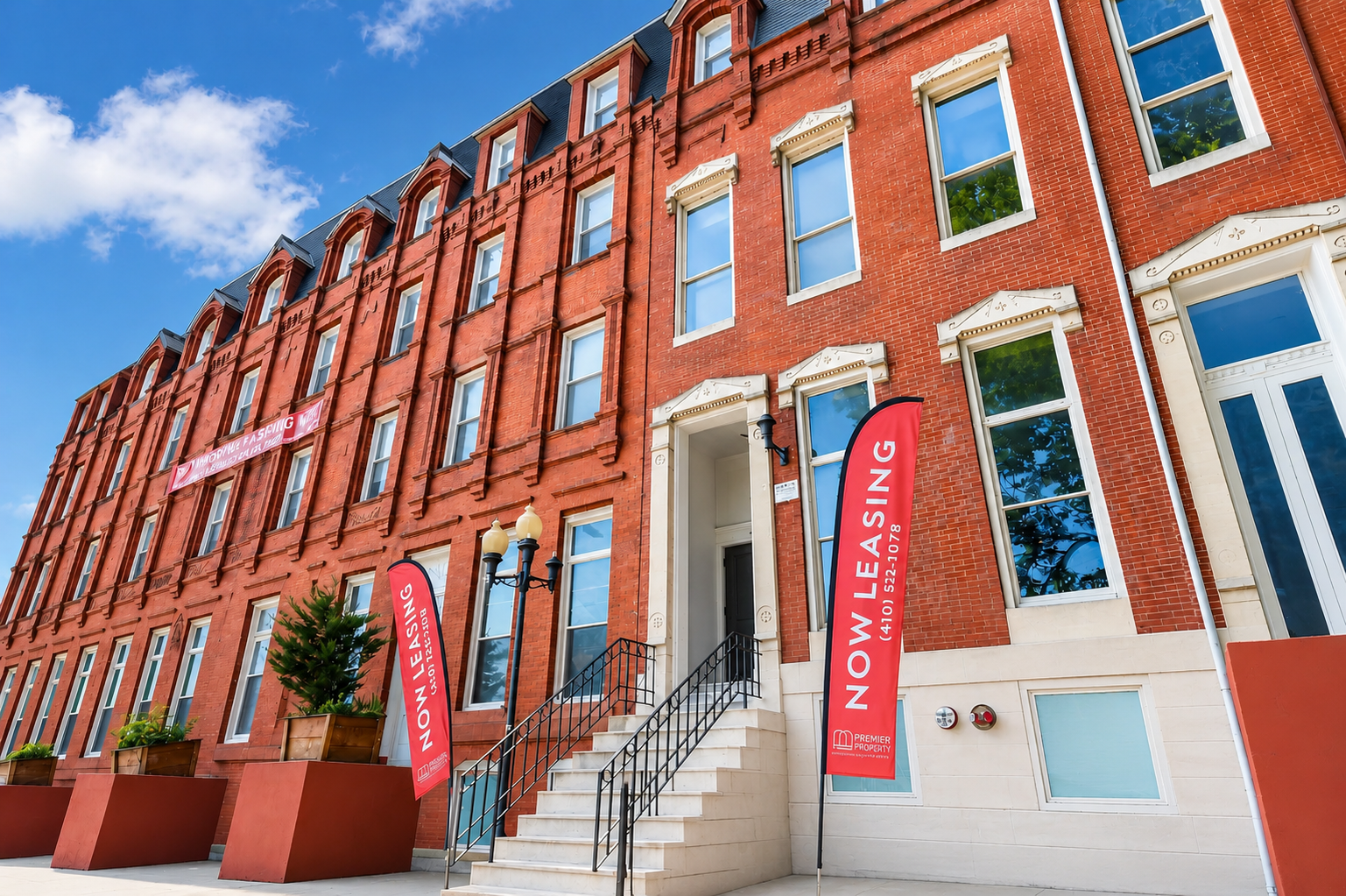 The McAllister brick apartment building on a sunny Baltimore street